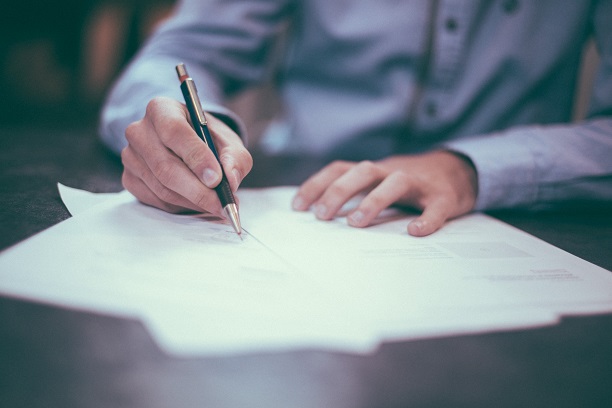 man writing document